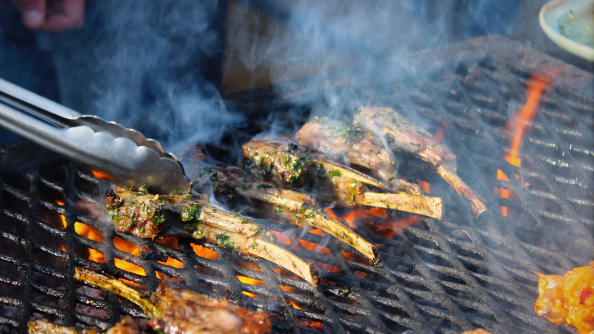 Smoke and fire on a grill with herbed lamb chops.