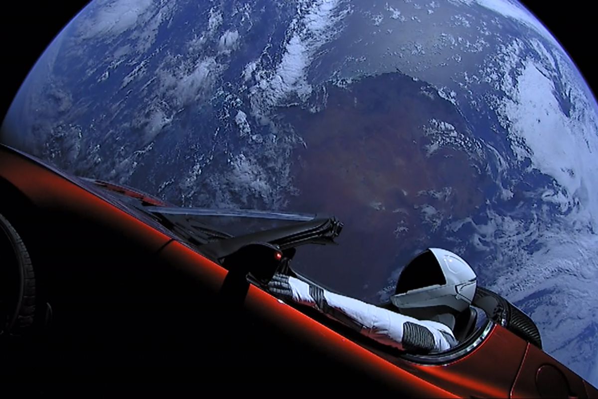 A Tesla roadster with an astronaut dummy driving it, with Earth in the background 
