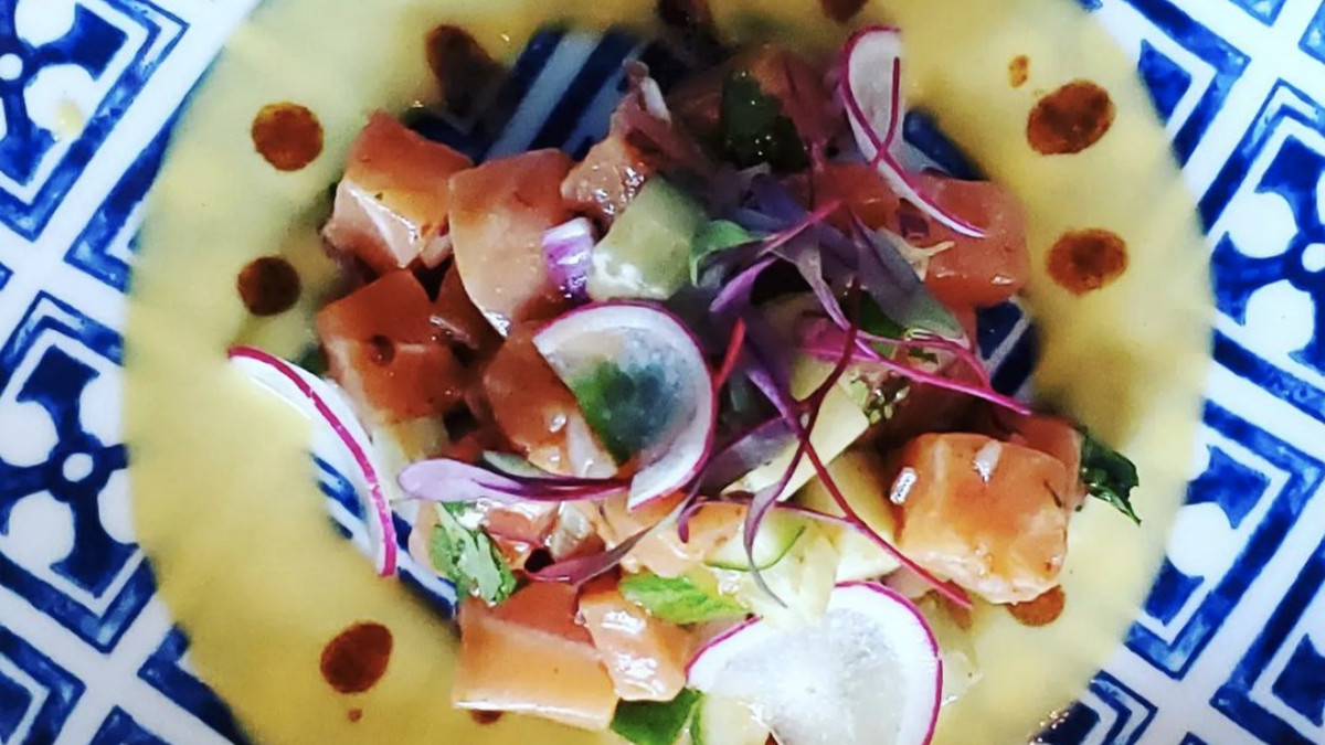 Salmon ceviche with passionfruit and chili oil in a blue and white bowl