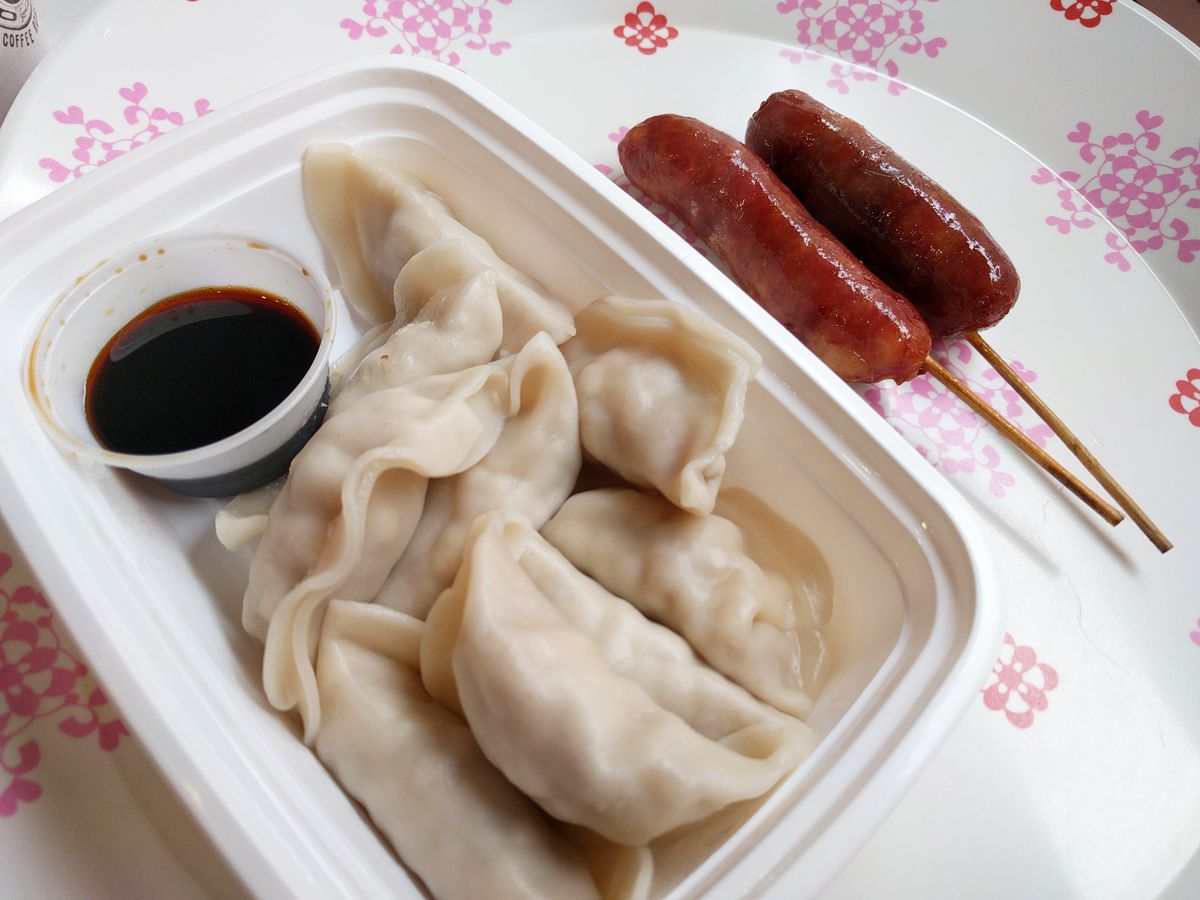 Oblong steamed dumplings with a dipping sauce, and stubby red sausages.