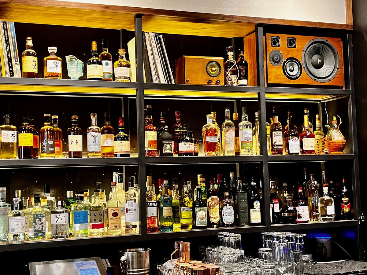 A bar with bottles and record players.