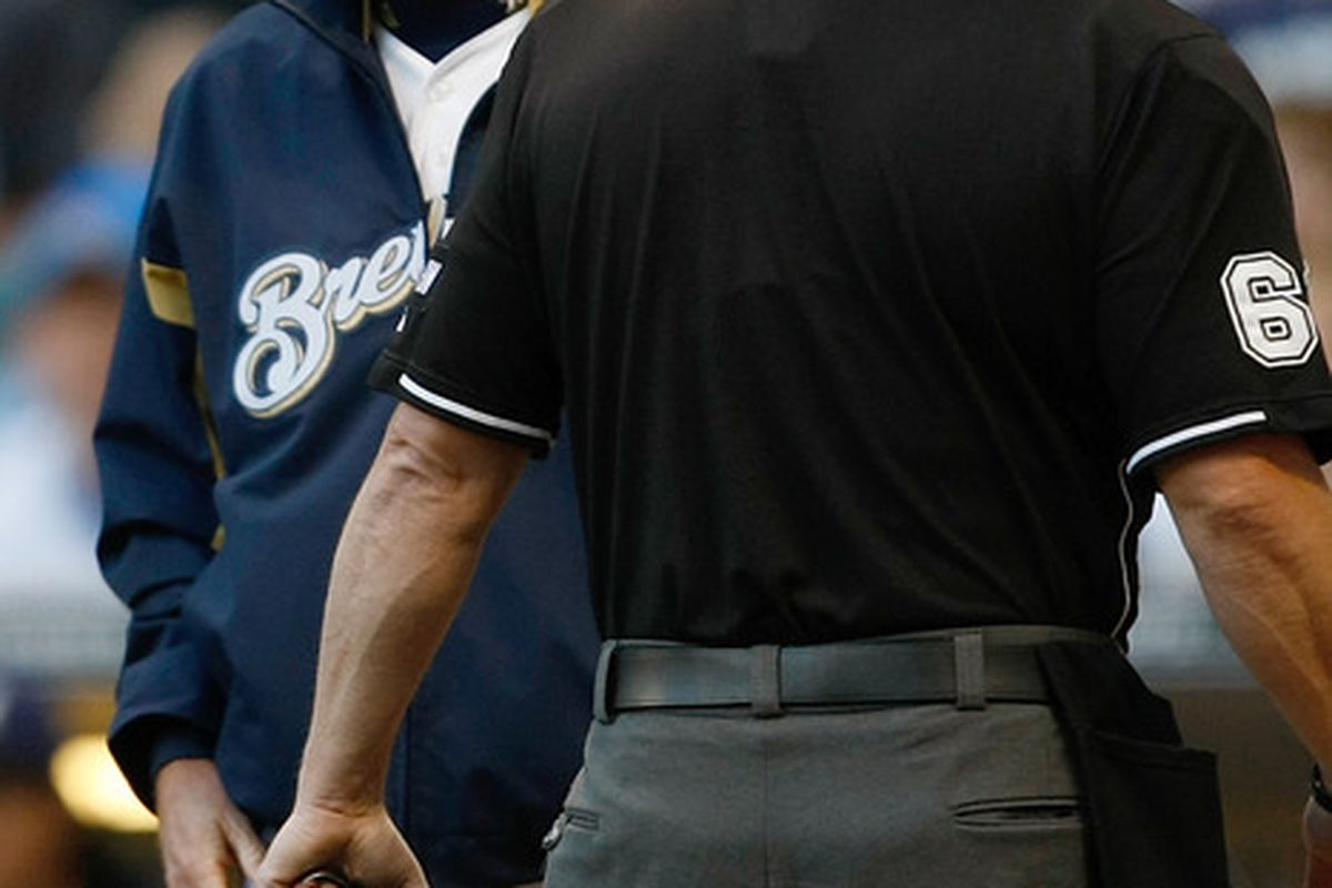 MILWAUKEE, WI - MAY 21: Ron Roenicke asks umpire Marty Foster if he's available to pitch out of the bullpen tonight.