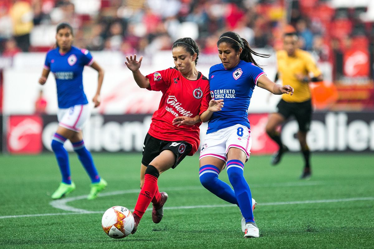 Patricia Gutiérrez and Reyna Velázquez fight for a loose ball in a match between Club Tijuana Femenil and Cruz Azul Femenil.