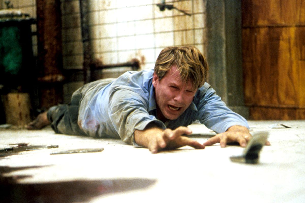 Cary Elwes weeps as he tries to reach a cell phone in the original 2004 Saw