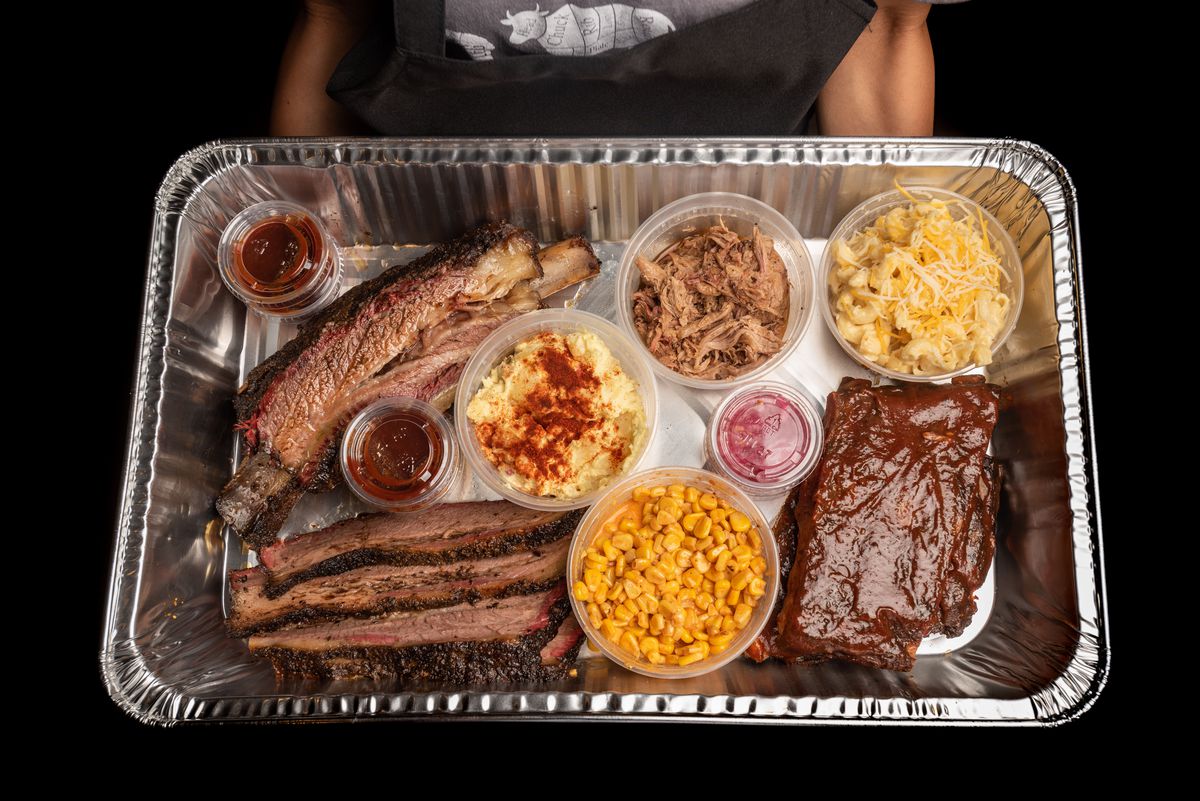 A silver tray filled with smoked meats shown from above.