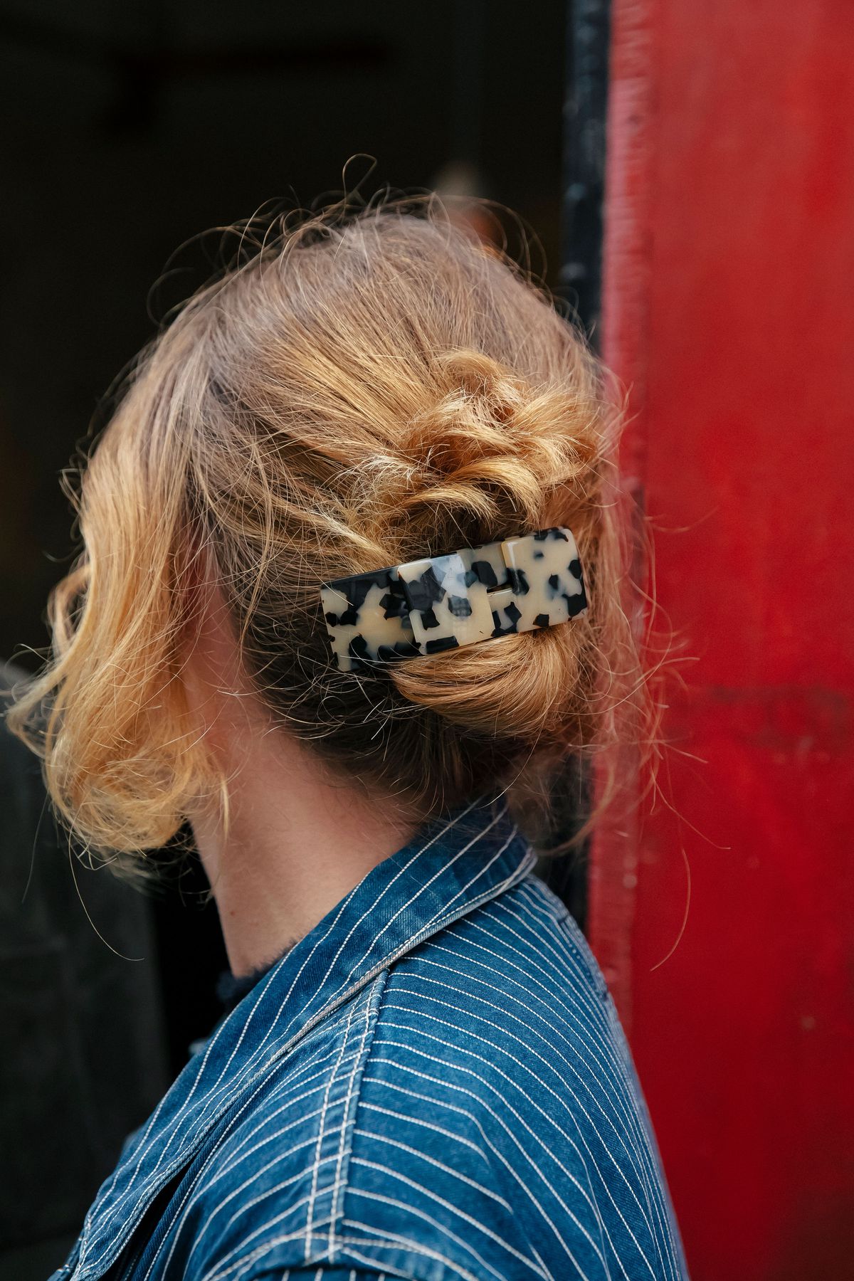 A photo of a woman’s leopard hair clip, holding her hair up.