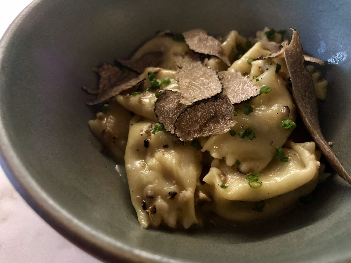 Pasta and truffles in a green ceramic bowl