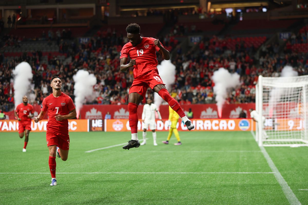Alphonso Davies leaps in the air to celebrate his penalty goal, Curaçao v Canada