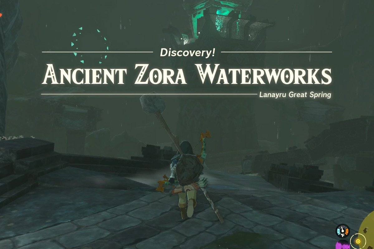 The quest title “Ancient Zora Waterworks” floats above link, who stands on a dirty stone floor.