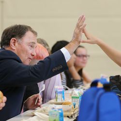 Gov. Gary Herbert high-fives a student while eating lunch at Rose Springs Elementary School in Stansbury Park on Wednesday, Aug. 22, 2018. During his visit, Herbert looked over school safety measures and met with Tooele County School District counselors to discuss aspects of school climate.