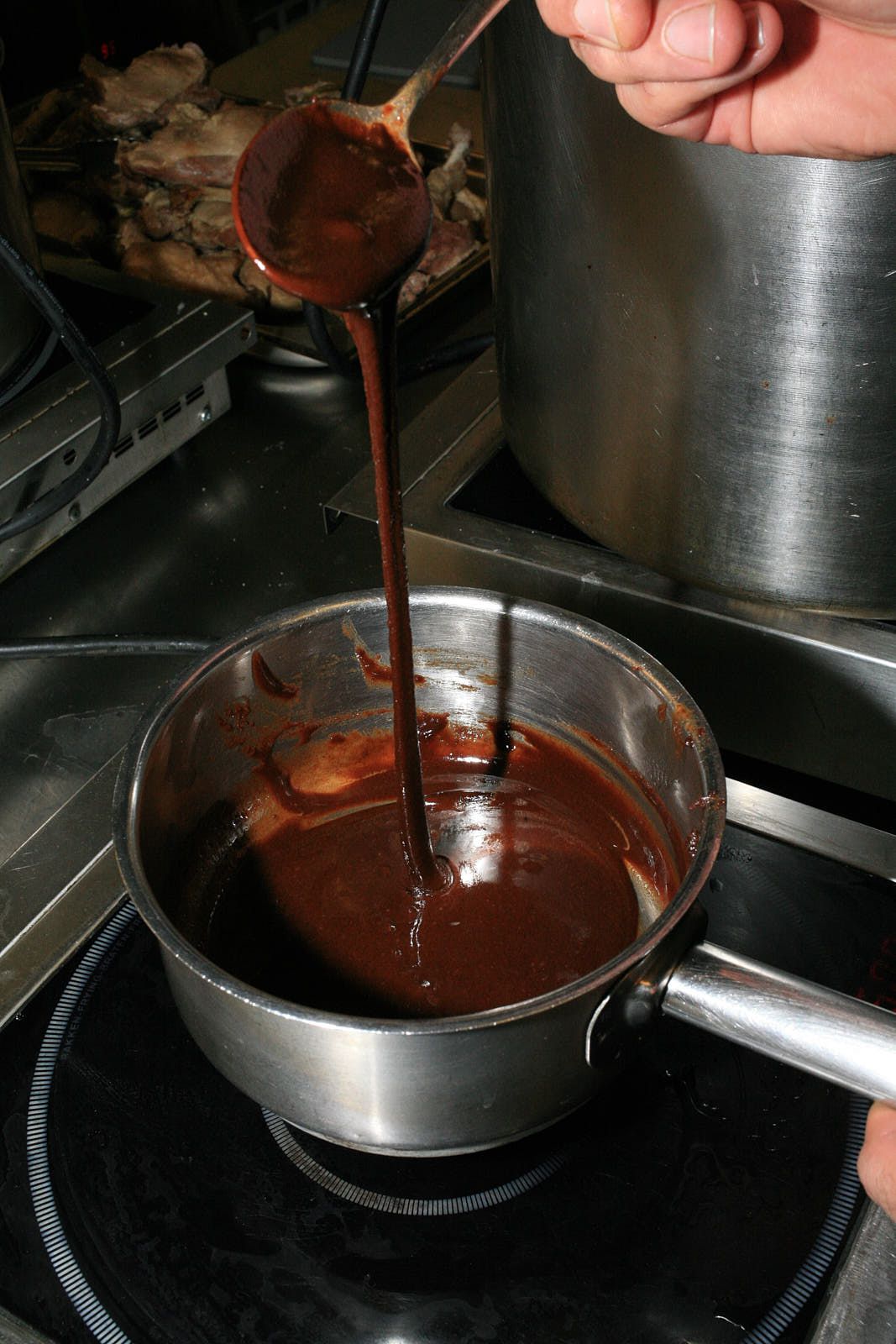 A pan of dark brown roux, as dark as dark chocolate, on the stove.