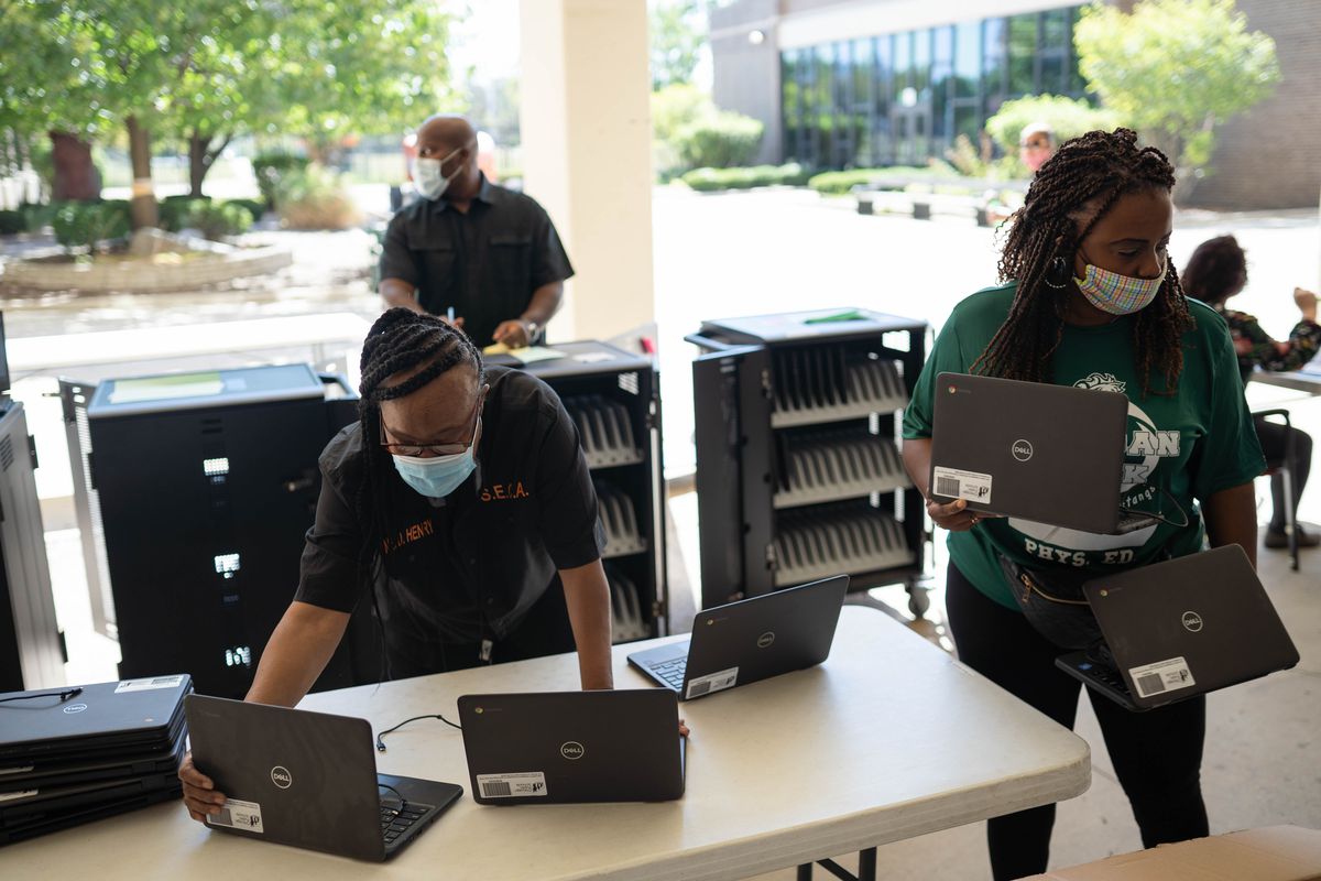 Staff members of Morgan Park High School prepare laptops to be distributed to students at Morgan Park High School in Morgan Park Saturday morning, Sept. 5, 2020.