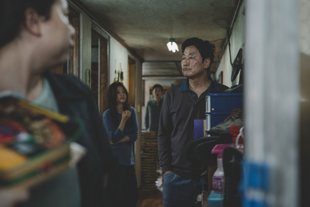 Kim Ki-taek (Song) stands in the middle of his home, surrounded by his family.