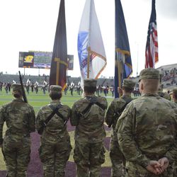 The color guard stands in the endzone awaiting pregame ceremonies. 