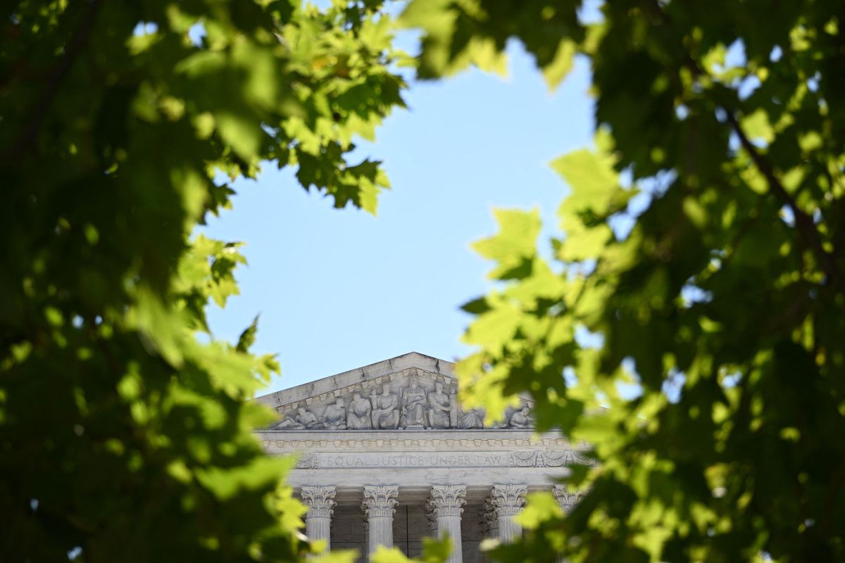 The Supreme Court building is pictured through a gap in the leaves of nearby trees