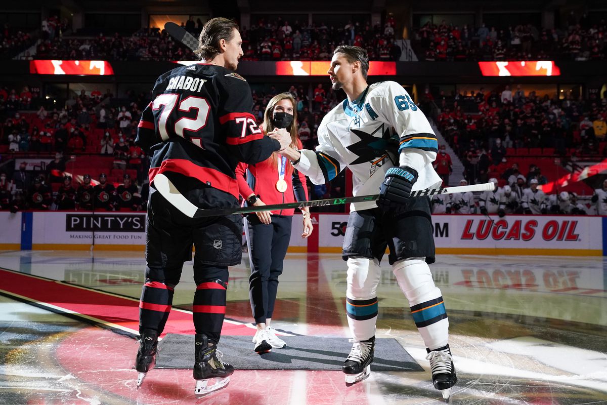 Thomas Chabot #72 of the Ottawa Senators and Erik Karlsson #65 of the San Jose Sharks shake hands after a ceremonial face-off at Canadian Tire Centre on October 21, 2021 in Ottawa, Ontario, Canada.