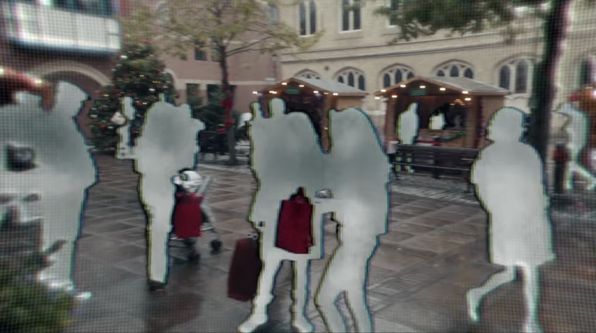 Photos of people through a technological lens, with people appearing as gray blurs and sort of pixelated in a still from the “White Christmas” episode of Black Mirror