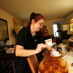 Sharon McRill, 43, owner of Betty Brigade, carefully organizes tea cups and water glasses before packing them up for EBAY while at a home in Ypsilanti, Mich.