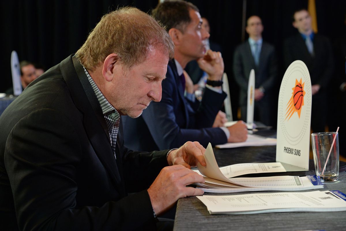 Robert Sarver looking through pages in a notebook at the draft lottery