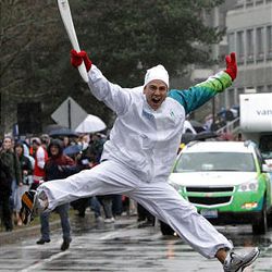 Torchbearer Michael Tchao jumps as he carries the Olympic flame during the Olympic torch relay at Simon Fraser University in Burnaby, British Columbia, on Thursday. The Olympic flame is on a 106-day journey across Canada in the longest domestic torch relay in Olympic history. It will end with the lighting of the Olympic caldron at the opening ceremonies for the Vancouver Winter Olympics on Friday.