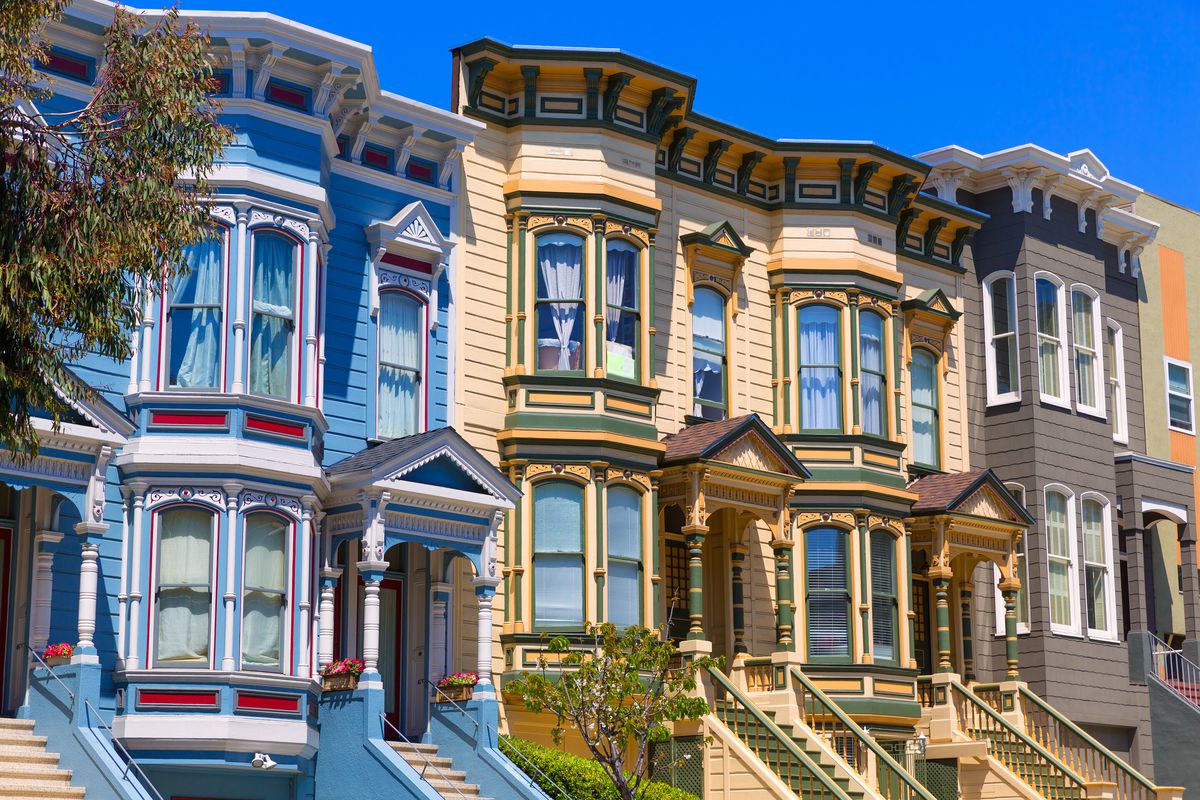 Colorful row homes in San Francisco, California painted yellow, blue, and brown. 