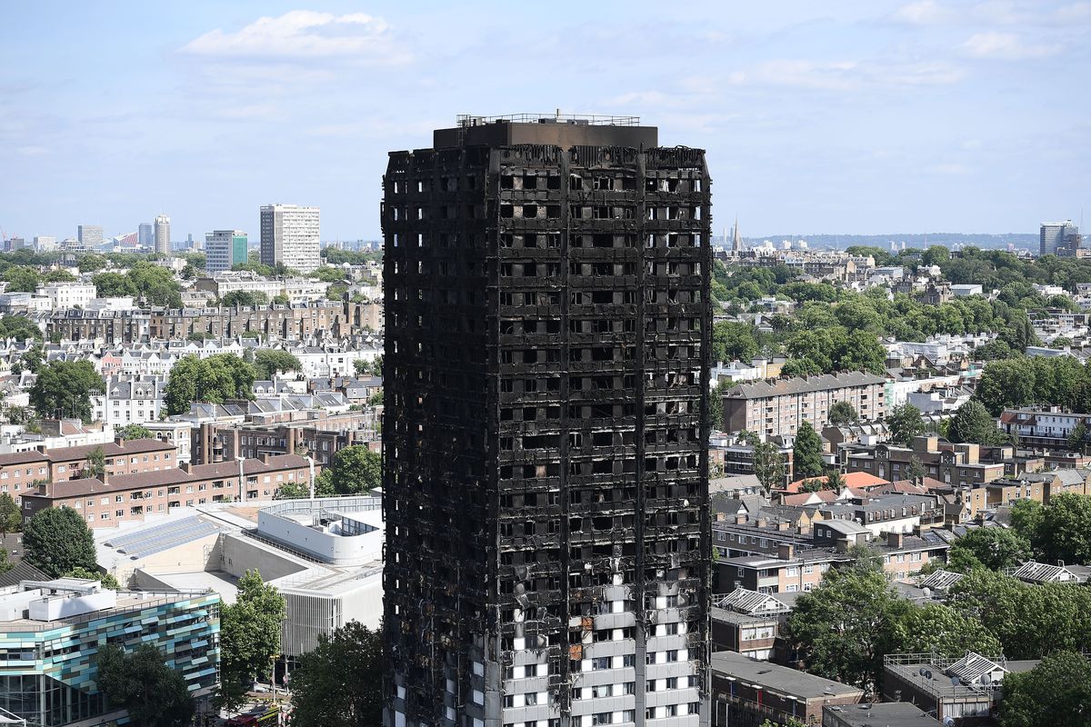 Grenfell Tower stands in the city and is scorched. 