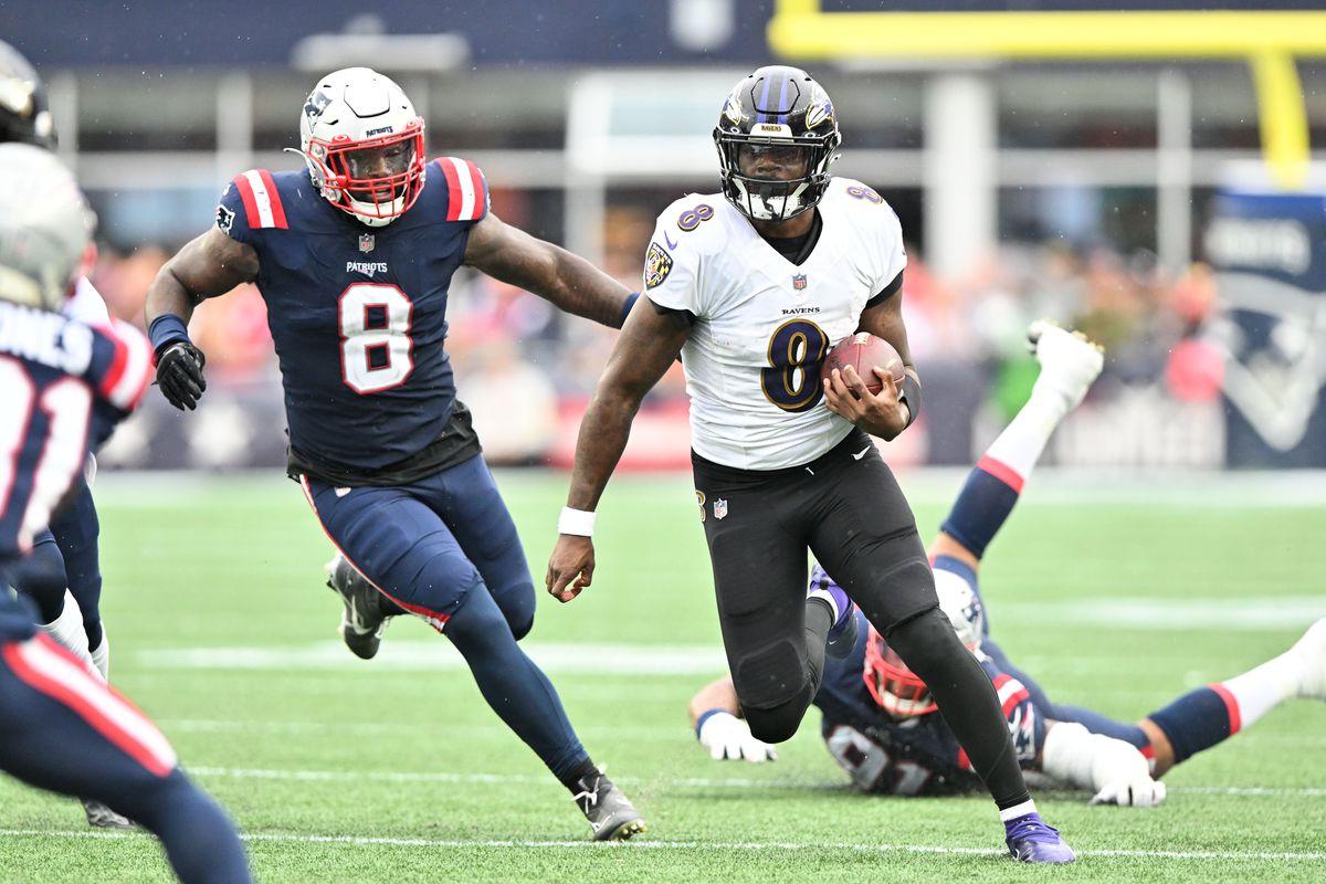 Baltimore Ravens quarterback Lamar Jackson runs with the ball in front of New England Patriots linebacker Ja’Whaun Bentley during the second half at Gillette Stadium.&nbsp;