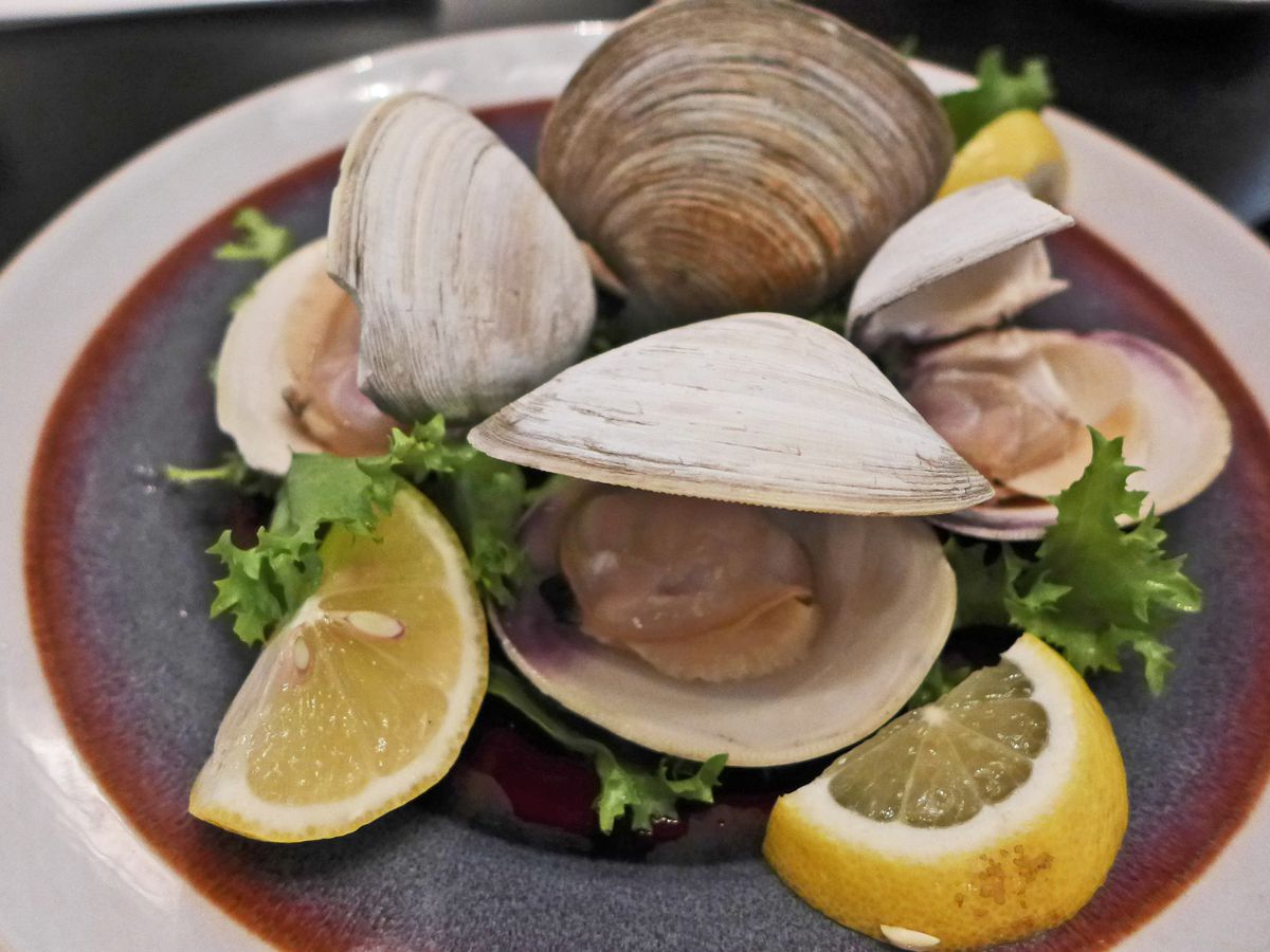 A bowl of clams with shells open so you can see the creatures inside.