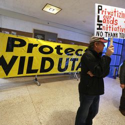 Peter Gatch holds a sign prior to the start of a meeting at the University of Utah where several hundred citizens gathered to voice their opinions on the proposed Public Lands Initiative on Wednesday, March 2, 2016. 