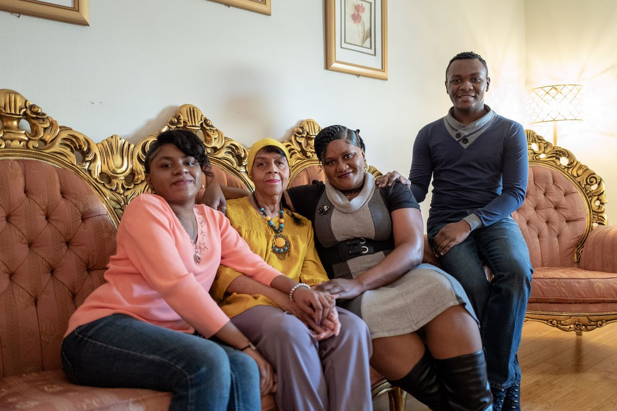 The Anderson family — Sara Alicia, Wilhelmina Elizabeth, Yolanda and Jonathan Pierre — sit in their living room in Oak Park. They used to live in the Austin community, but the family decided to move out when they could not keep up with the financial costs of maintaining their pink-and-white Victorian house.