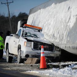 Officials look over an accident on U.S. Route 13 on Thursday, Feb. 19, 2015 in Melfa, Va.  A Virginia Department of Transportation worker was injured when a tractor-trailer truck crushed the driver's side of this VDOT truck. According to a release the tractor-trailer spun out on U.S. Route 13 and rolled over onto the VDOT truck. The worker suffered a back injury and was released from a local hospital later in the morning.  