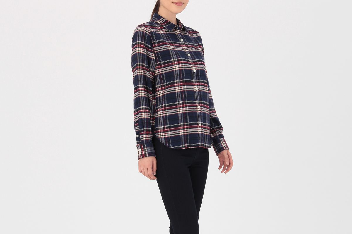 A model wearing a flannel shirt and black leggings and sneakers
