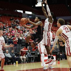 Utah guard Justin Bibbins (1) leaps jumps around the defense of Washington State guard Carter Skaggs, left, and guard Viont'e Daniels, third from right, to shoot during the first half of an NCAA college basketball game, Saturday, Feb. 17, 2018, in Pullman, Wash. (AP Photo/Ted S. Warren)