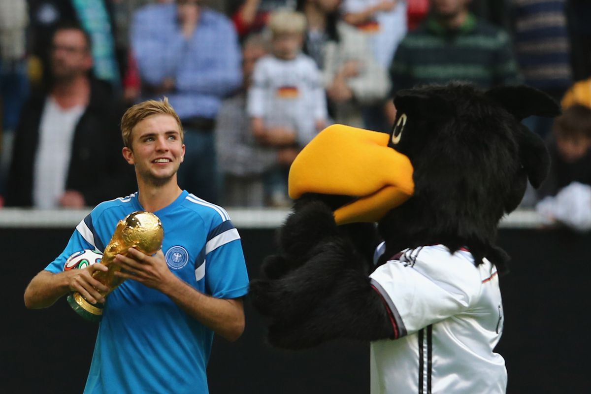 Gladbach's Kramer with the WC Trophy.  I have no idea about the crow.