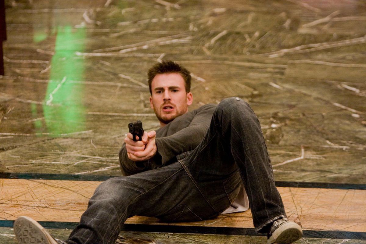 Chris Evans on his back holding a gun in Push