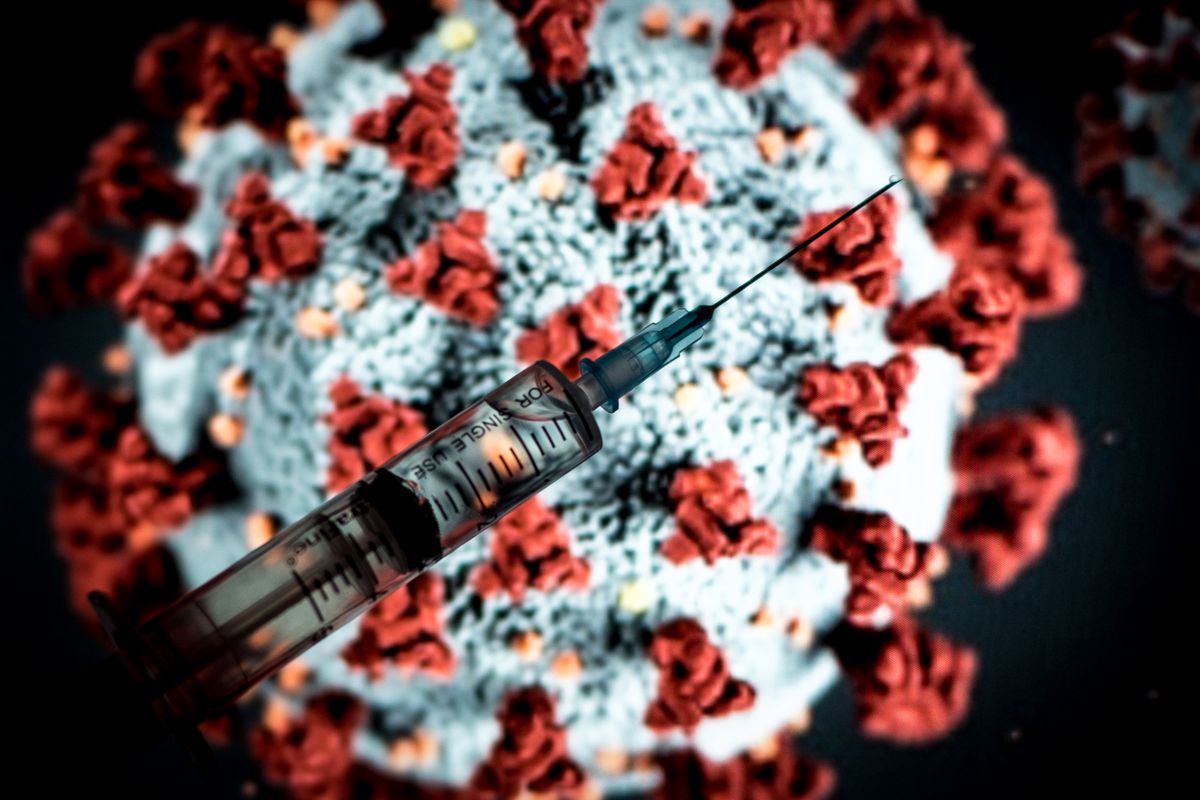 Illustration with a photo of a medical syringe in front of a model of the SAR-CoV-2 coronavirus.