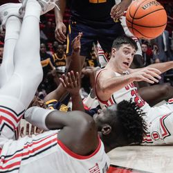 Utah guard Lazar Stefanovic, back, California forward Andre Kelly, left, and Utah center Lahat Thioune clash as they attempt to reach a loose ball during an NCAA game at the Huntsman Center in Salt Lake City on Sunday, Dec. 5, 2021.