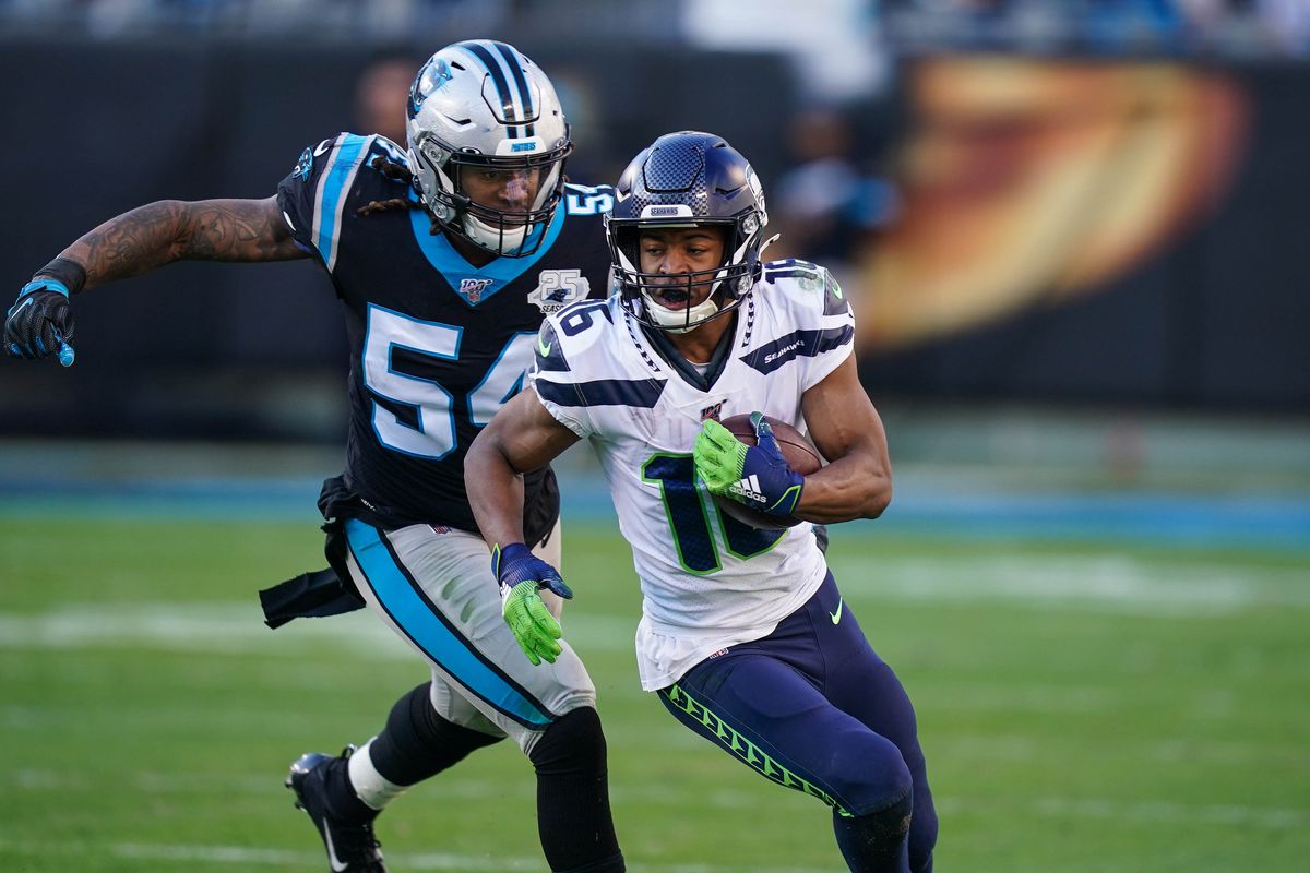 Carolina Panthers outside linebacker Shaq Thompson catches Seattle Seahawks wide receiver Tyler Lockett during the second half at Bank of America Stadium.