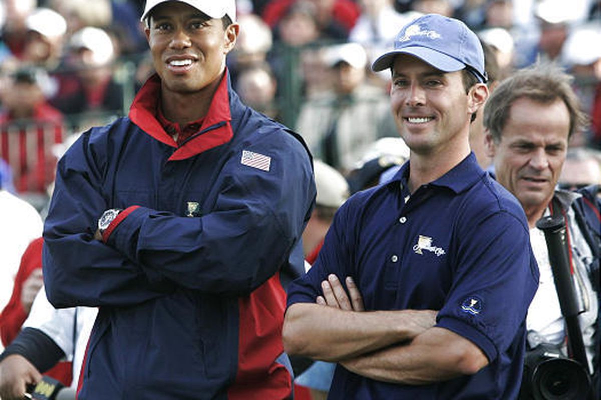 Tiger Woods, left, and International team member Mike Weir take in the conclusion of play following Weir's 1-up victory on Sunday.