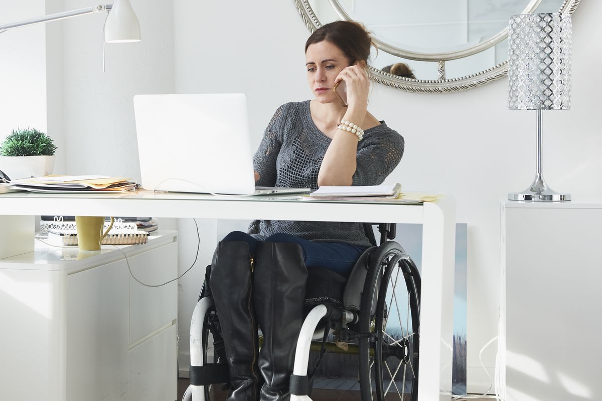 A woman in a wheelchair working.