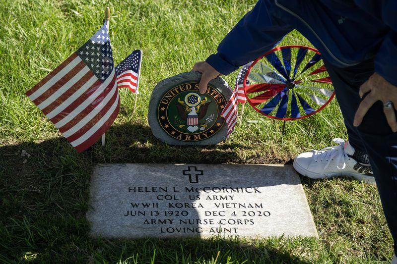 Kathleen Frost Roth, a relative of Col. Helen L. McCormick, tends to the headstone on hers grave at St. Mary Catholic Cemetery and Mausoleums in Evergreen Park, much as McCormick would do for her family members.