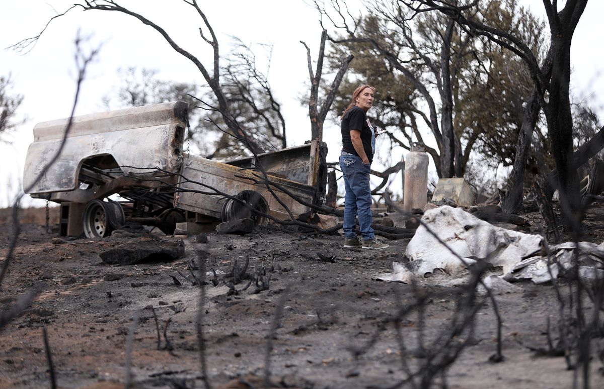 Linda Adams looks at what's left of her Fruitland home on Wednesday, July 11, 2018. The Dollar Ridge Fire destroyed her home, shed and camper.