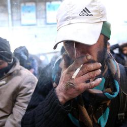In this Tuesday, Feb. 3, 2015 photo, a drug addict smokes cigarette at drop-in center and shelter south of Tehran, Iran. Anti-narcotics and medical officials say more than 2.2 million of Iran's 80 million citizens already are addicted to illegal drugs, including 1.3 million on registered treatment programs. 