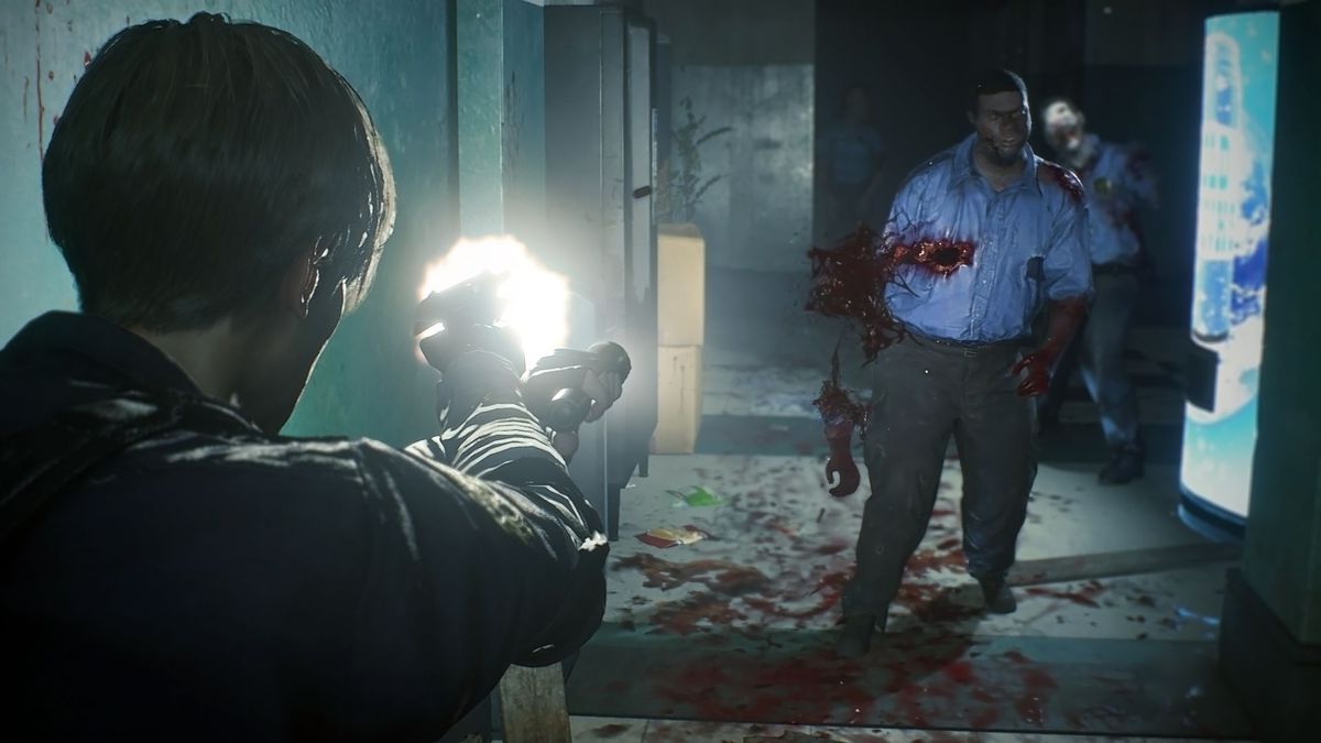 Leon S. Kennedy fires his handgun at encroaching zombie police officers in a dark hallway in Raccoon Police Station