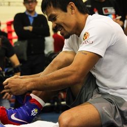 Manny Pacquiao lacing up his boxing shoes