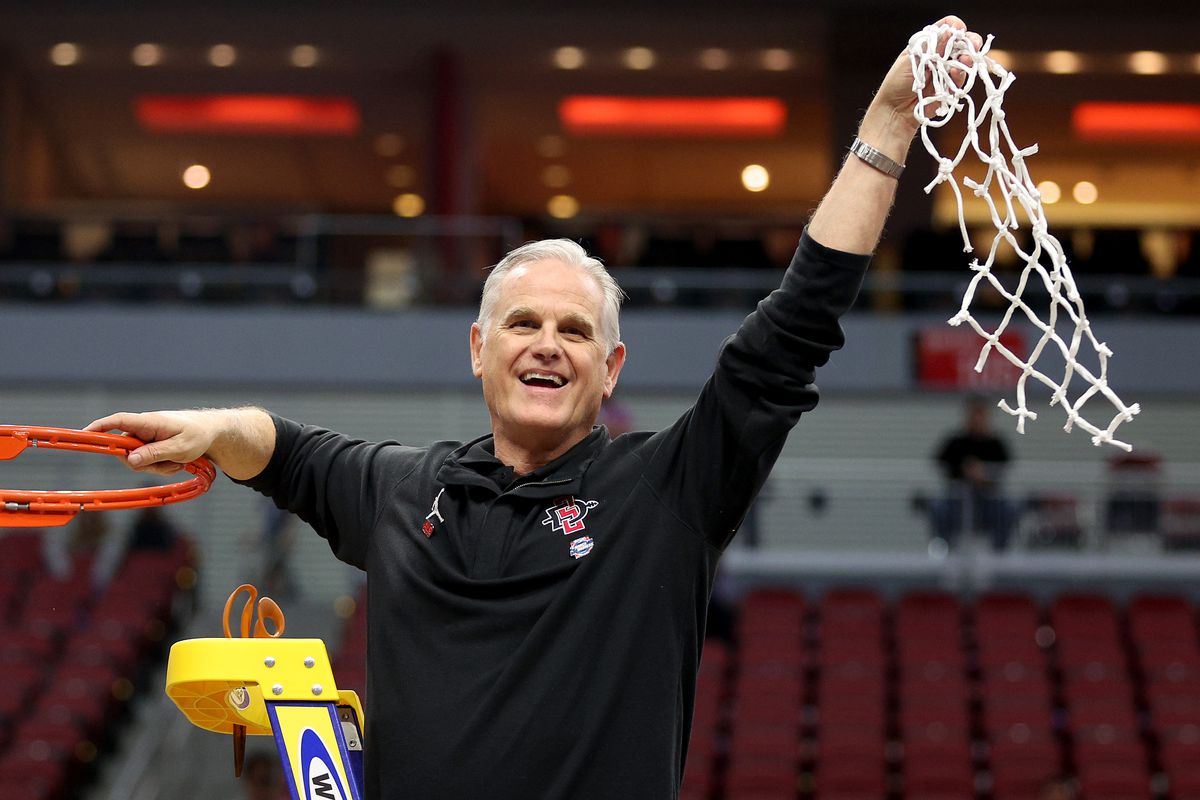 Head coach Brian Dutcher of the San Diego State Aztecs celebrates by cutting down the net after defeating the Creighton Bluejays in the Elite Eight round of the NCAA Men’s Basketball Tournament at KFC YUM! Center on March 26, 2023 in Louisville, Kentucky.