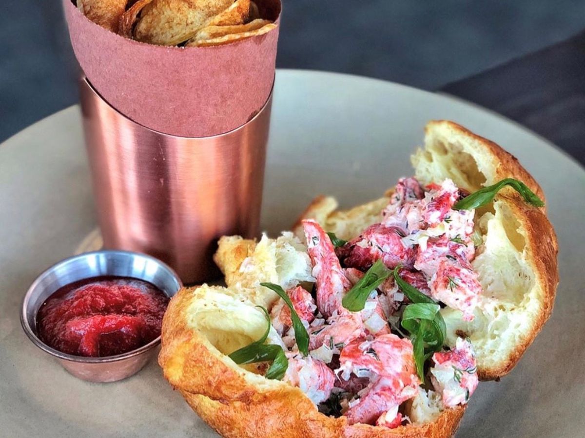 A popover is split open to reveal a lobster salad filling.