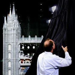 Lee Alger, staging specialist for the LDS Conference Center, unveils a 7-foot-tall, scaled architectural model of the LDS Salt Lake Temple on Friday in the South Visitors' Center at Temple Square in Salt Lake City. The model is 1/32nd the size of the actual temple.