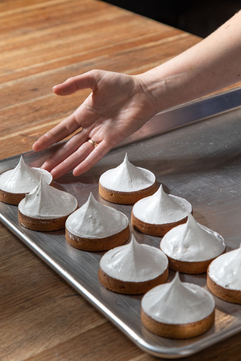 A tray full of meringue-topped tarts. 