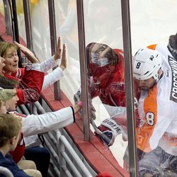 Backstrom Protects Puck on Boards From Grossmann